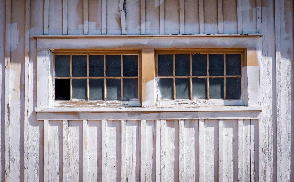 Old wooden window on a wall with peeling paint.