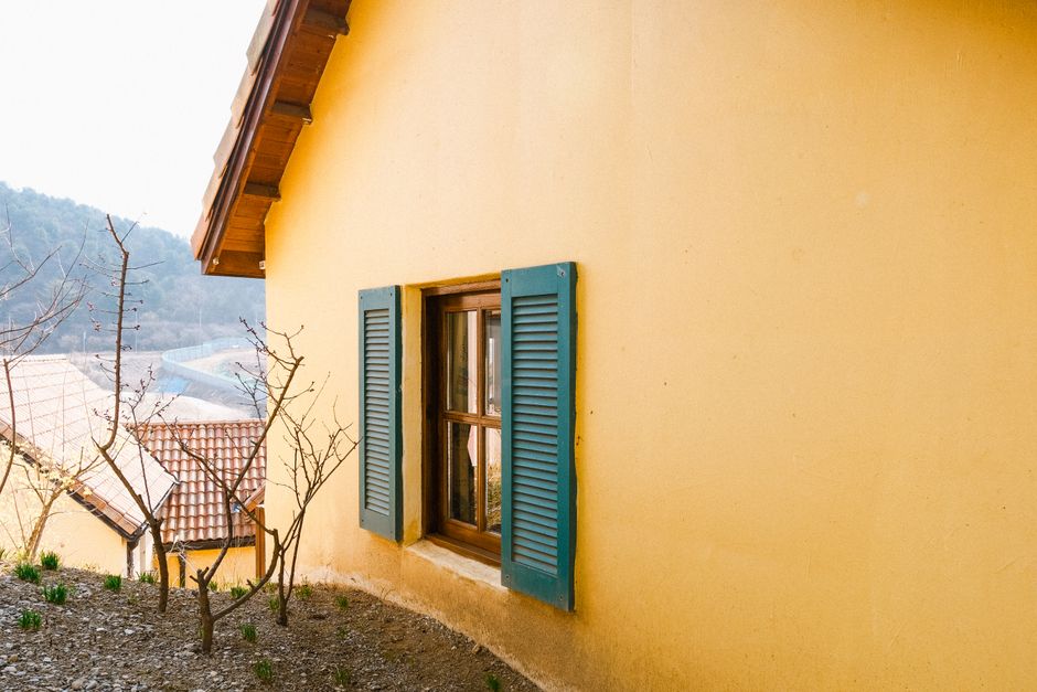 Yellow house with blue shutters.