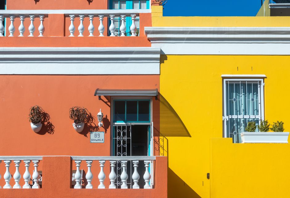 Row of buildings with orange and yellow painted fronts.
