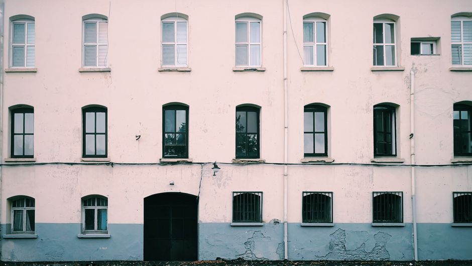 Front of an older building with a row of windows.